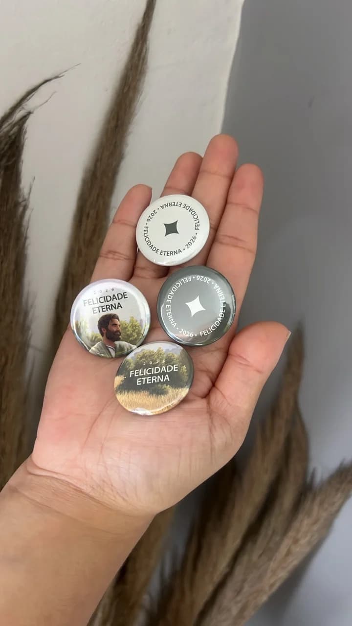 Foto real de quatro bottons Memmoria com diferentes artes na palma da mão
